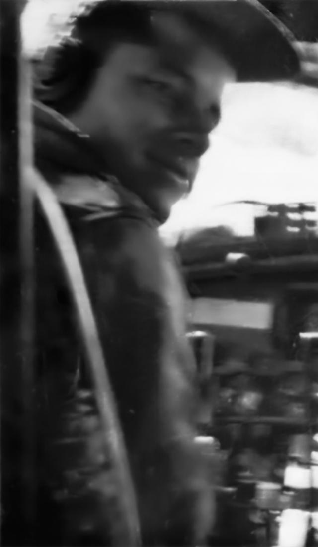 Pilot Frank J. Calicura in the left-hand seat of a B-17, garrison cap and leather jacket, the instrument panel beside him